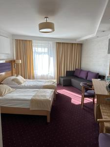 a hotel room with two beds and a couch at Diament i Brylant in Rawicz