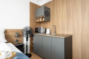 a small kitchen with a sink and a microwave at Cozy Studio Kwiatowa Poznań by Renters in Poznań