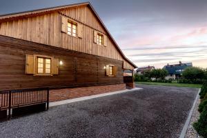 a wooden house with windows and a driveway at Vila IVAN in Velika Gorica