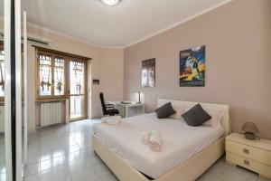 Schlafzimmer mit einem weißen Bett und einem Schreibtisch in der Unterkunft MM Bengasi Modern Apartment in Turin