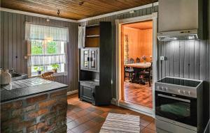 een keuken met een fornuis top oven naast een tafel bij Stunning Home In Eidsberg With Kitchen 