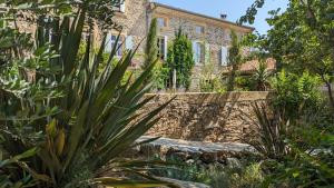 an old stone house with plants in front of it at LA GALANTE in Faugères