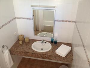 a bathroom with a sink and a mirror at Apartamentos Marivent in Cala en Blanes +25 photos