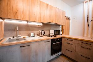 a kitchen with a sink and a microwave at Vila Kollár Apartmán Rosa 14 in Vysoké Tatry