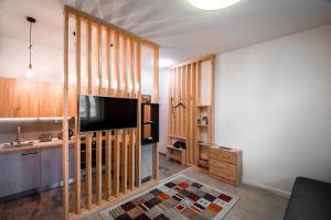 a living room with wooden walls and a flat screen tv at Vila Kollár Apartmán Rosa 14 in Vysoké Tatry