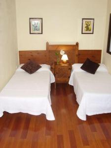 Habitación de hotel con 2 camas y suelo de madera. en CHALET PRIVADO, PISCINA, WIFI AL MEJOR PRECIO, en San Juan de la Rambla