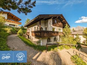 a house in the mountains with a balcony at Chalet Steinbock by Arosa Holiday in Arosa