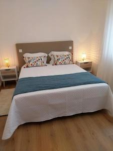 a bedroom with a large white bed with two pillows at Casa com ALma in Fátima