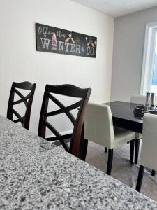 une salle à manger avec une table et des chaises noires dans l'établissement New luxury spacious 3BR 3BA 1 mile from Mt Snow, à Dover
