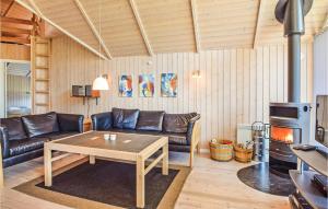 SønderbyにあるAmazing Home In Juelsminde With 3 Bedrooms, Sauna And Wifiのリビングルーム(ソファ、テーブル、コンロ付)