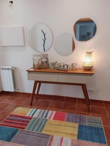 a table with two mirrors and a tv on a wall at Casa com ALma in Fátima