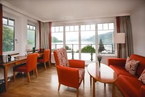 a living room with a couch and a table and chairs at Seehotel Billroth in Sankt Gilgen