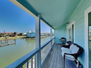 a porch with two chairs and a view of the water at Canal Royale in Rockport