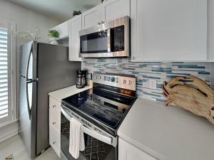 a kitchen with a stove top oven next to a refrigerator at Canal Royale in Rockport