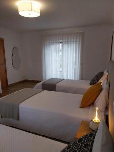 a hotel room with two beds and a window at Casa com ALma in Fátima