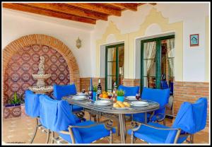 comedor con mesa y sillas azules en Villa El Pedregal, en Frigiliana