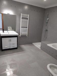 a bathroom with a sink and a toilet and a tub at Casa com ALma in Fátima