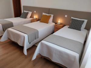 a room with two beds with white sheets at Casa com Alma by LovelyStay in Fátima +29 photos