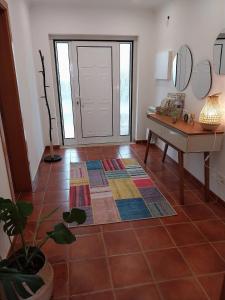a room with a door and a table and a floor at Casa com ALma in Fátima