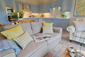 Afon Menai في Gaerwen: غرفة معيشة مع أريكة ومطبخ