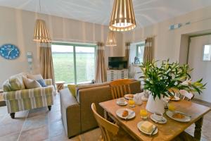 Afon Menai في Gaerwen: غرفة معيشة مع طاولة وأريكة