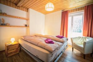 ein Schlafzimmer mit einem Bett mit lila Handtüchern darauf in der Unterkunft Chasa Gisep in Scuol