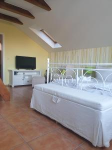 Schlafzimmer mit einem weißen Bett und einem TV in der Unterkunft Ferienanlage Traumhaft in Wernigerode