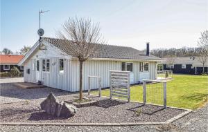 una pequeña casa blanca con un árbol delante en 3 Bedroom Beautiful Home In Juelsminde, en Sønderby
