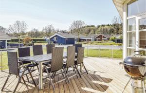 a patio with a table and chairs and a grill at 3 Bedroom Beautiful Home In Juelsminde in Sønderby