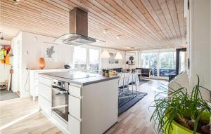 オルダーにあるAwesome Home In Odder With Wifiの白いキャビネットと木製の天井が備わるキッチン