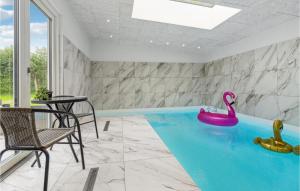 a swimming pool with a pink swan in a room at Awesome Home In Nibe With Kitchen in Nibe