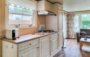 a kitchen with a sink and a stove at Nice Home In Heinkenszand With Wifi in Heinkensand