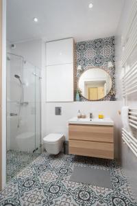a bathroom with a sink and a mirror at Białego Dębu Cosy Apartment in Warsaw
