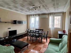sala de estar con mesa y sofá en Bonito apartamento cerca de la playa, en Valencia