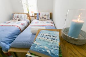 a book on a table with a candle and two beds at Tyddyn Waen in Llanddona