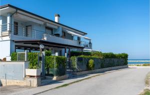 a white house with a fence in front of the ocean at Stunning Apartment In Porto Santelpidio With Wifi in Porto SantʼElpidio