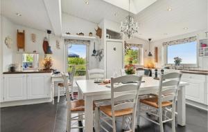 a white kitchen with a white table and chairs at Awesome Home In Asns With Wifi in Asnæs