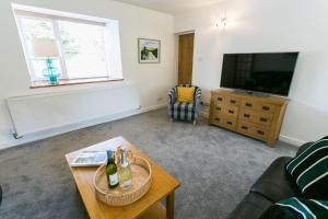 a living room with a couch and a tv and a table at Tyddyn Waen in Llanddona