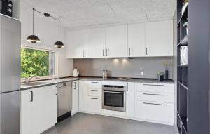 cocina blanca con armarios blancos y ventana en Nice Home In Ebeltoft With Kitchen en Ebeltoft