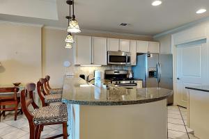a kitchen with a counter top and a kitchen with a refrigerator at Wharf #506 in Orange Beach