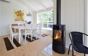 グレーノにあるLovely Home In Grenaa With Kitchenのリビングルーム(暖炉、テーブル、椅子付)