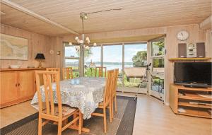 een eetkamer met een tafel en uitzicht op de oceaan bij Lillebo in Brejning