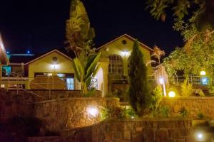 une maison la nuit avec des lumières devant elle dans l'établissement Emerald Villa, à Kigali