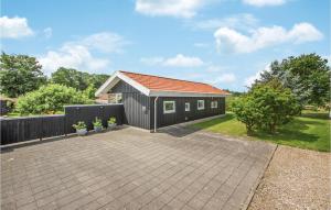 a small black building with a pitched roof at Amazing Home In Brkop With 3 Bedrooms, Sauna And Wifi in Brejning