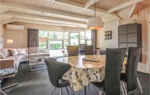 a dining room with a table and chairs at Amazing Home In Brkop With 3 Bedrooms, Sauna And Wifi in Brejning