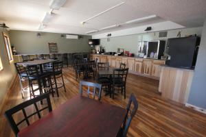 a dining room with tables and chairs and a kitchen at Blackstone Lodge and Suites in Lead