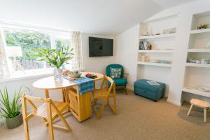 a living room with a table and chairs at Borth Bach in Rhosneigr