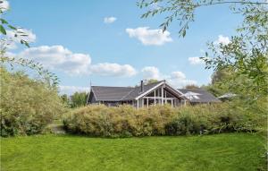 エーベルトフトにあるBeautiful Home In Ebeltoft With 5 Bedrooms, Sauna And Wifiの茂みの庭中の家