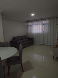 sala de estar con sofá y mesa en Lindo apto praia do bessa, en João Pessoa