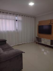 a living room with a couch and a flat screen tv at Lindo apto praia do bessa in João Pessoa